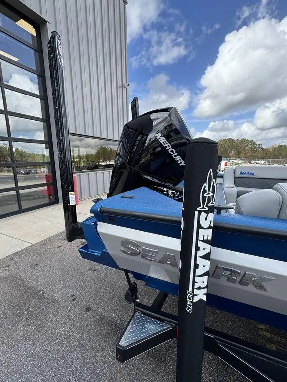 Slide: The Image of 2025 SeaArk Super Lounge Easy boat with powerful outboard motor, parked outdoors. - 7