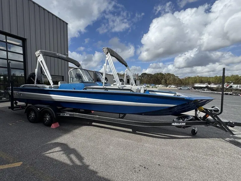 Slide: The Image of 2025 SeaArk Super Lounge Easy boat on trailer, blue and white, parked outdoors. - 9