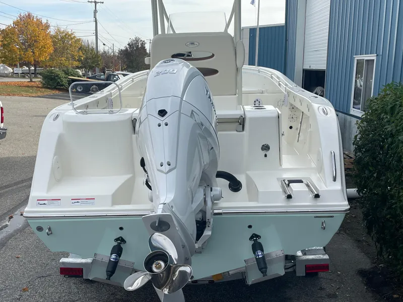Slide: The Image of 2025 Cobia 220 Center Console boat with outboard motor, parked outdoors. - 2