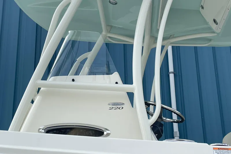Slide: The Image of 2025 Cobia 220 Center Console boat with sleek design against blue background. - 4