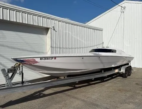 Slide: The Image of 2019 Phantom SV 32 speedboat on trailer, parked near white building. - 2