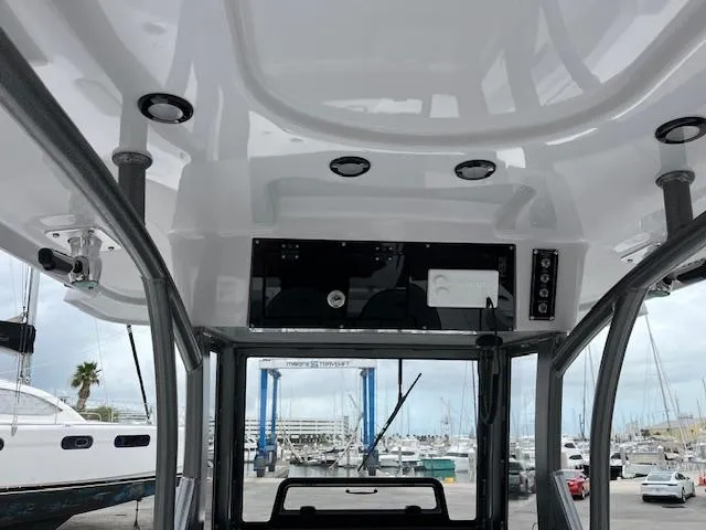 Slide: The Image of 2025 Sea Pro 262 Sport boat interior with overhead console and marina view. - 7