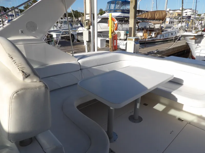 Slide: The Image of 1998 Wellcraft Martinique 3600 yacht interior with white seating and table at marina. - 12