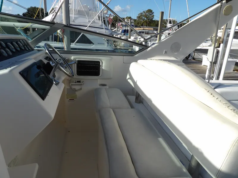 Slide: The Image of 1998 Wellcraft Martinique 3600 boat interior with white seating and steering wheel. - 17