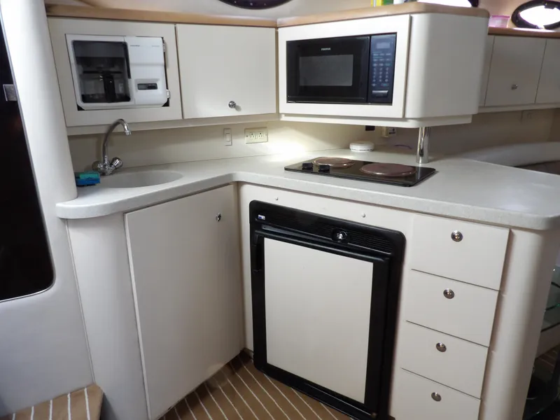 Slide: The Image of 1998 Wellcraft Martinique 3600 yacht kitchen with microwave, sink, and fridge. - 20