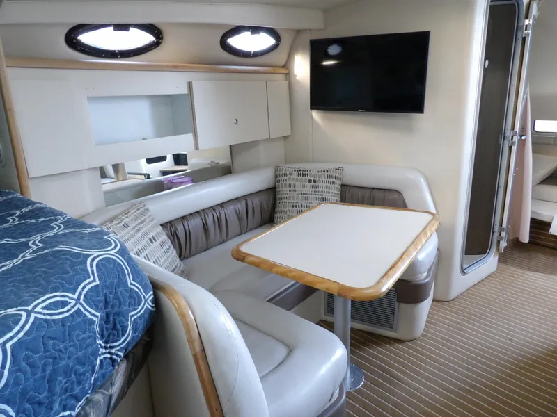 Slide: The Image of 1998 Wellcraft Martinique 3600 interior with cozy seating, table, and TV. - 26