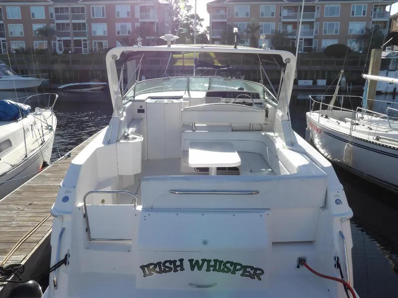 Slide: The Image of 1998 Wellcraft Martinique 3600 boat docked, featuring spacious seating and "Irish Whisper" name. - 5