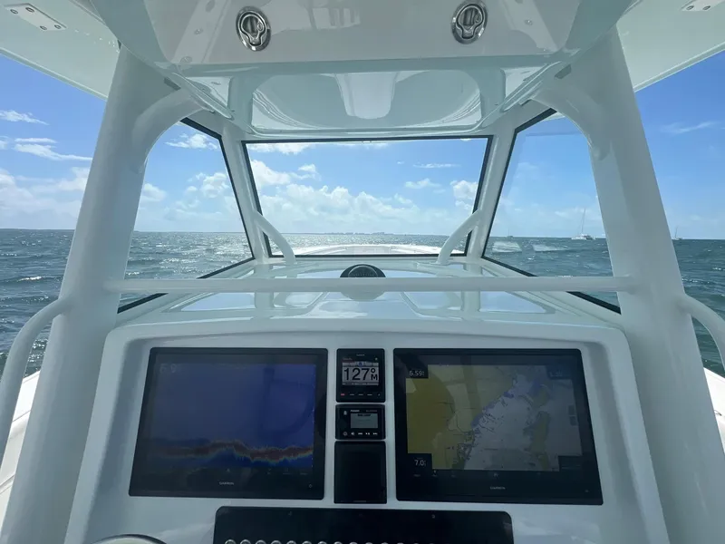 Slide: The Image of 2017 Yellowfin 39 Offshore boat dashboard with navigation screens, ocean view, and clear sky. - 13