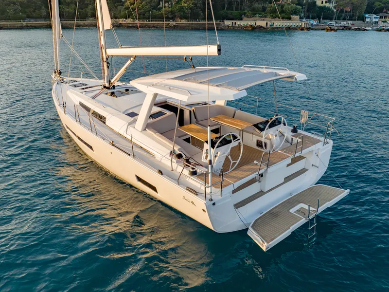 Slide: The Image of 2025 Hanse 460 yacht on calm water, featuring dual steering wheels and spacious deck. - 0
