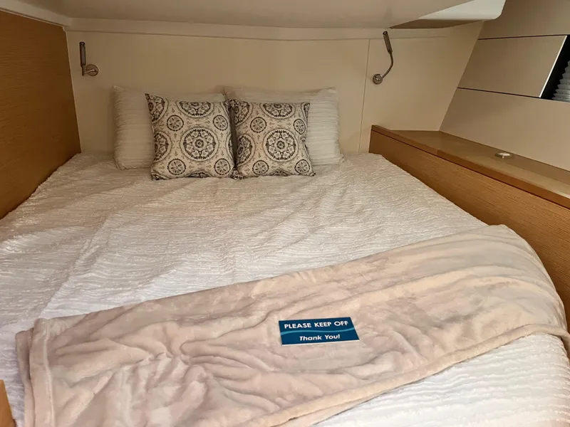 Slide: The Image of Cozy bedroom in 2025 Hanse 460 yacht with decorative pillows and a "Please Keep Off" sign. - 19