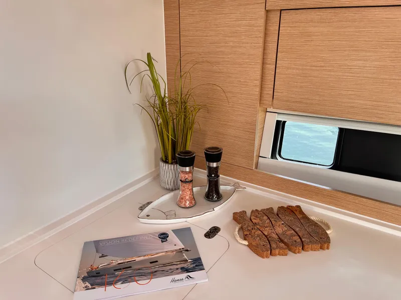 Slide: The Image of Interior of 2025 Hanse 460 yacht with bread, spices, and a brochure. - 33