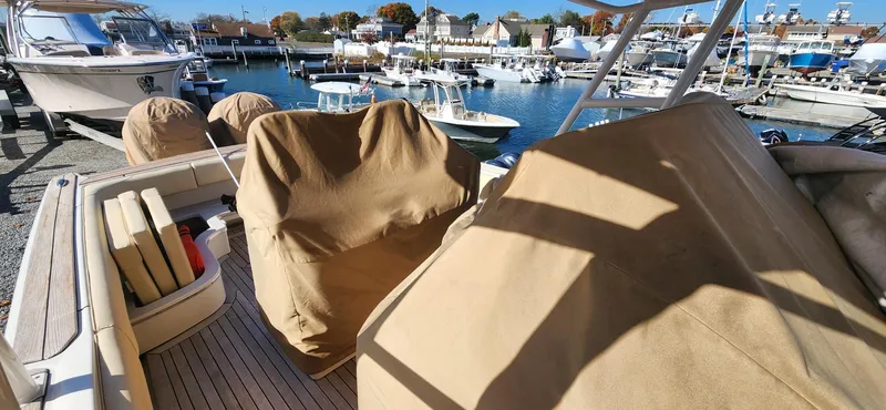 Slide: The Image of 2013 Chris-Craft Catalina 29 Sun Tender with covered seats at a marina. - 13