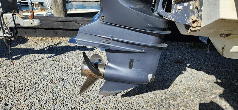 Slide: The Image of 2013 Chris-Craft Catalina 29 Sun Tender outboard motor and propeller on gravel. - 14