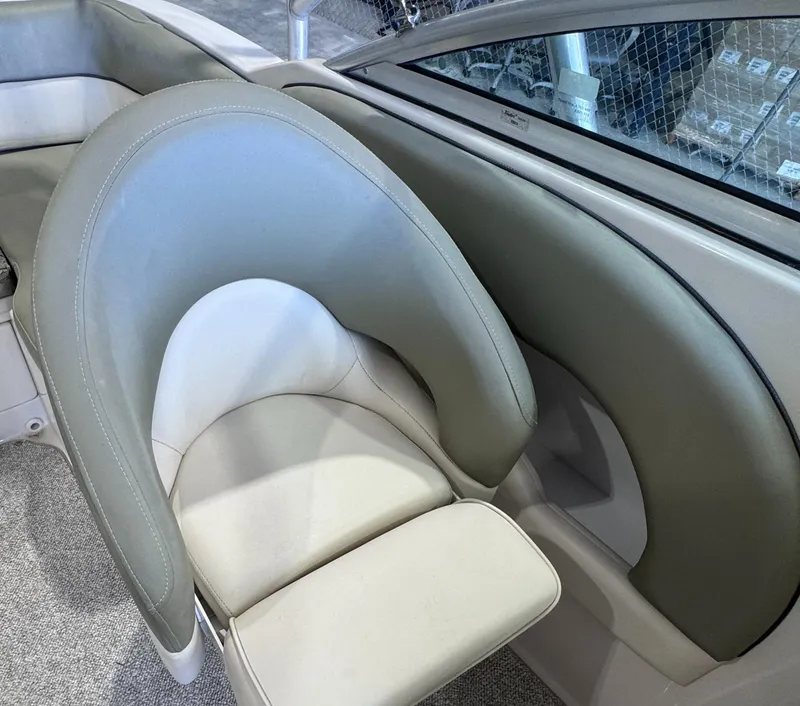 Slide: The Image of 2005 Sea Ray 220 Sundeck boat interior with beige seating and carpeted flooring. - 4
