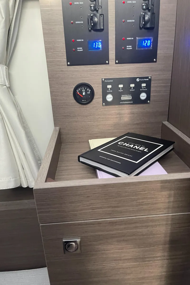 Slide: The Image of Control panel and books inside 2025 Jeanneau NC 895 Series 2 cabin. - 14