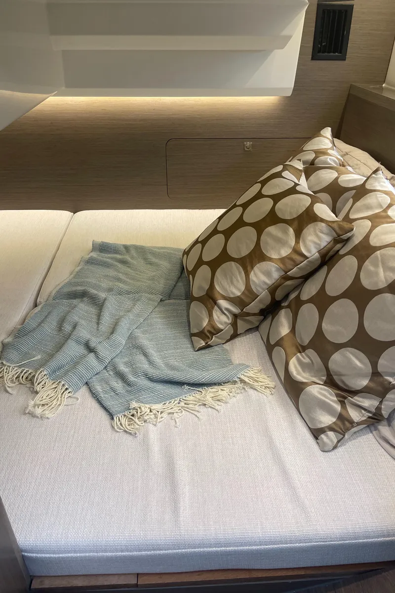 Slide: The Image of Cozy interior of 2025 Jeanneau NC 895 Series 2 with polka dot pillows and blanket. - 20