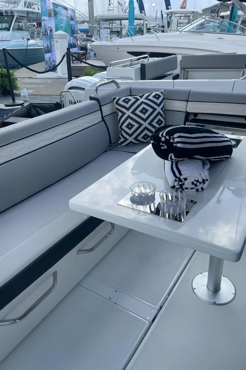 Slide: The Image of 2025 Jeanneau NC 895 Series 2 boat interior with seating and table setup. - 5