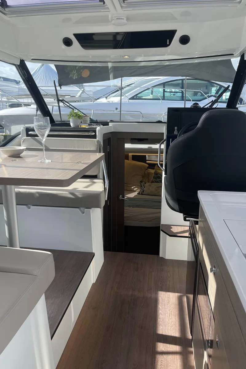 Slide: The Image of Interior cabin of 2026 Jeanneau NC 895 Series 2, featuring wood paneling and a window. - 21