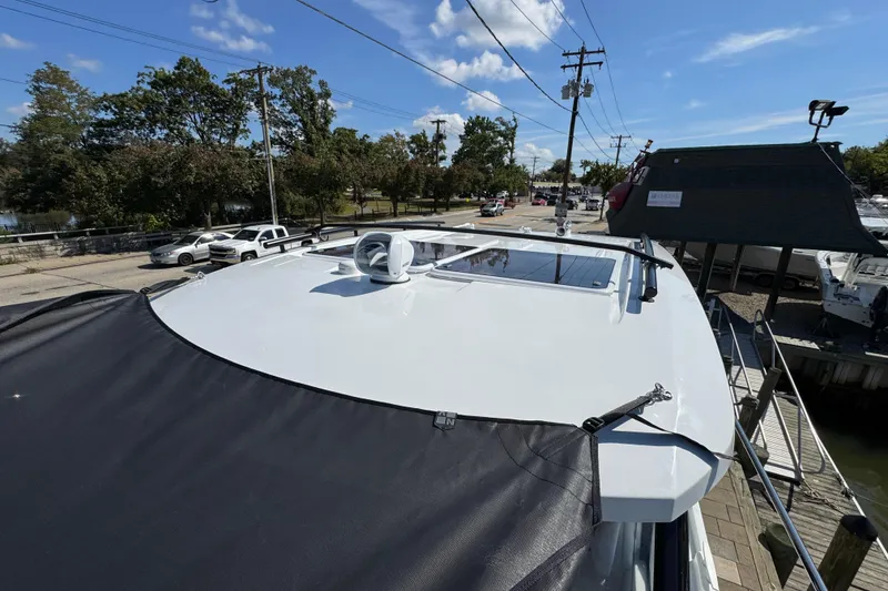 Slide: The Image of 2026 Jeanneau NC 895 Series 2 boat roof with skylight, docked near trees and parked cars. - 41