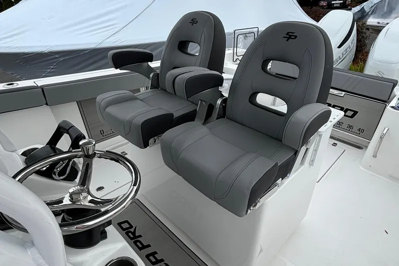 Slide: The Image of 2025 Sea Pro 292 DLX boat interior with dual gray captain's chairs and steering wheel. - 12