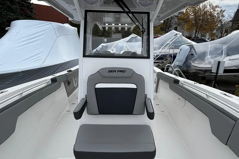 Slide: The Image of 2025 Sea Pro 292 DLX boat interior with seating and covered boats in background. - 6