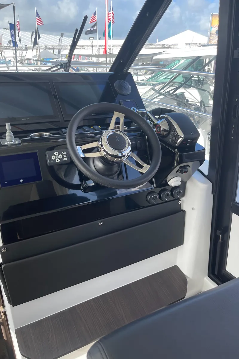 Slide: The Image of 2025 Jeanneau NC 1295 Coupe helm with modern steering and controls. - 10