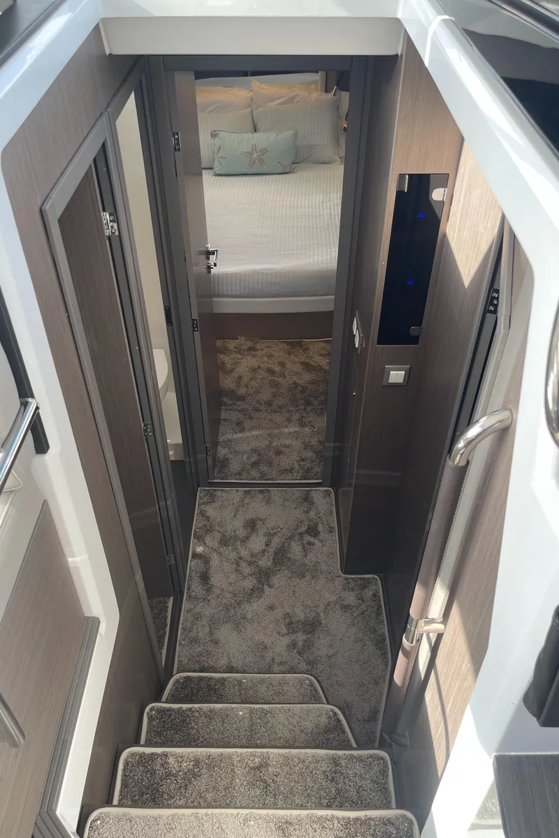 Slide: The Image of Interior view of 2025 Jeanneau NC 1295 Coupe, featuring stairs and cozy bedroom. - 12