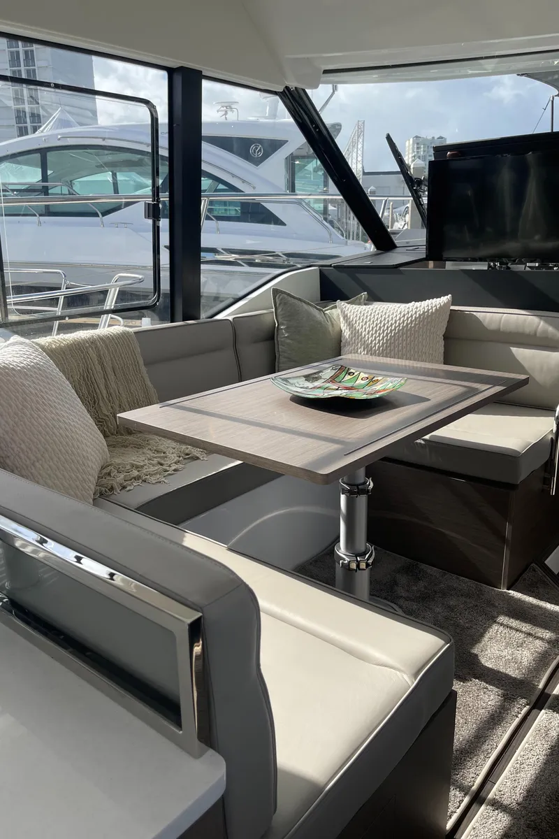Slide: The Image of Luxurious interior of 2025 Jeanneau NC 1295 Coupe yacht with elegant seating and table. - 7