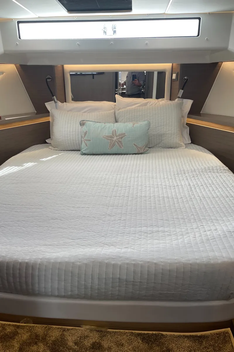 Slide: The Image of Luxurious bedroom in 2025 Jeanneau NC 1295 Coupe yacht with elegant bedding. - 16