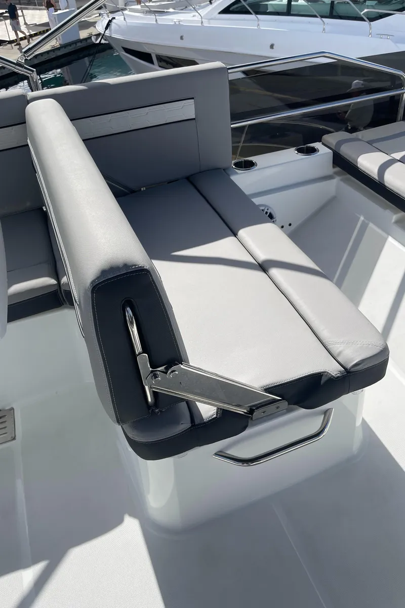 Slide: The Image of 2025 Jeanneau NC 1295 Coupe boat with sleek gray seating and modern design. - 19