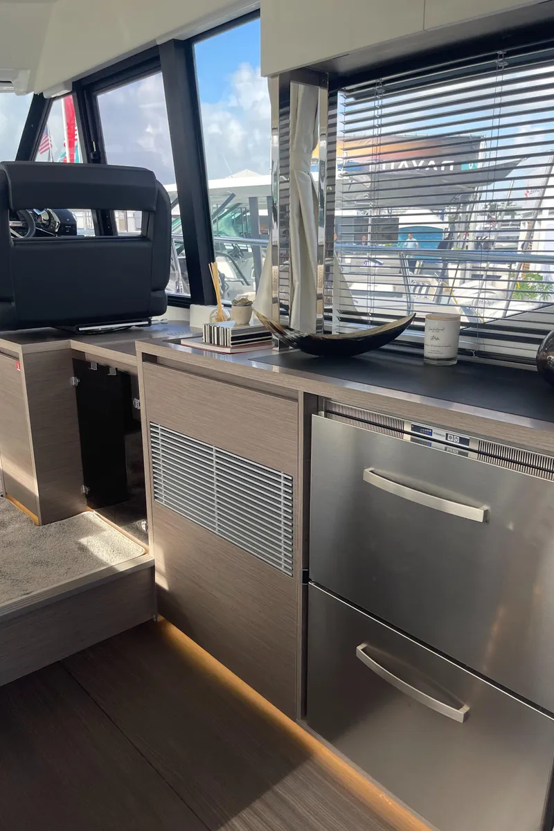 Slide: The Image of 2025 Jeanneau NC 1295 Coupe interior with modern kitchen appliances and sleek design. - 6