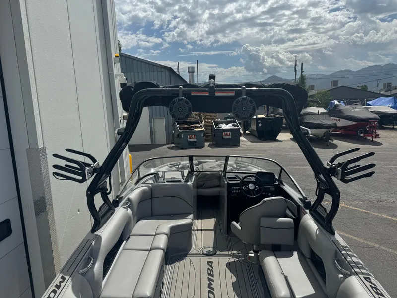 Slide: The Image of 2021 Moomba Craz boat interior with seating and wakeboard tower under cloudy sky. - 5
