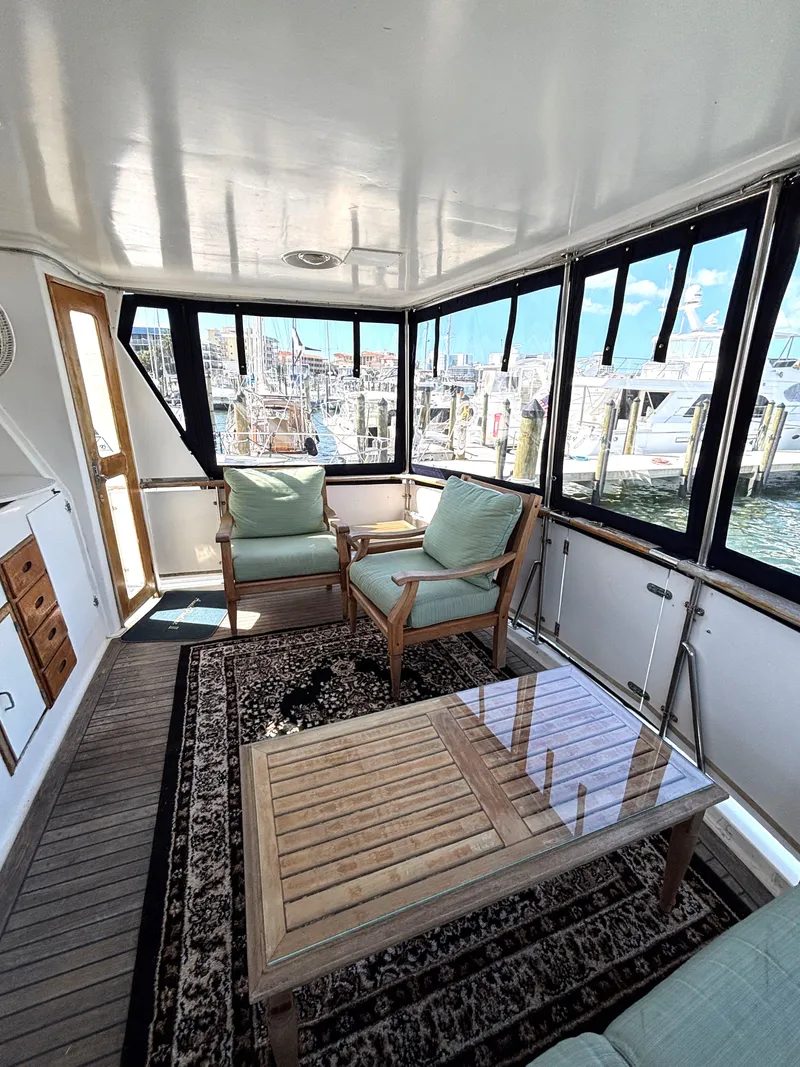 Slide: The Image of 1988 Marine Trader Tradewinds 43 Motor Yacht interior with seating and table, dockside view. - 11