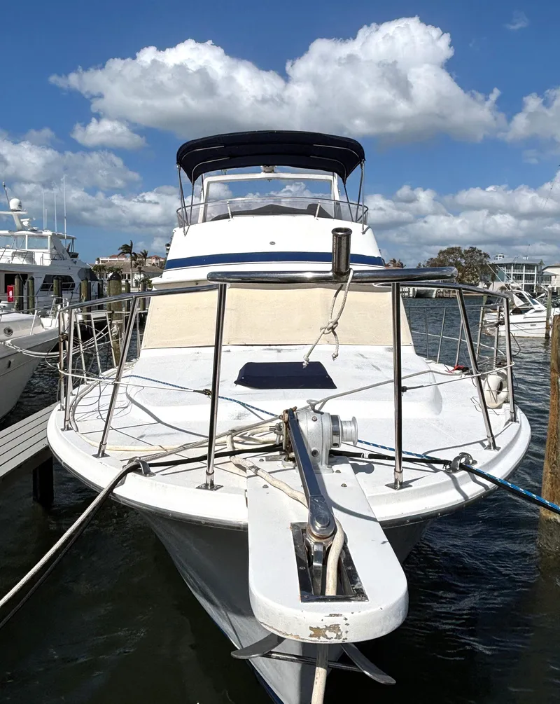 Slide: The Image of 1988 Marine Trader Tradewinds 43 Motor Yacht docked under blue skies. - 2