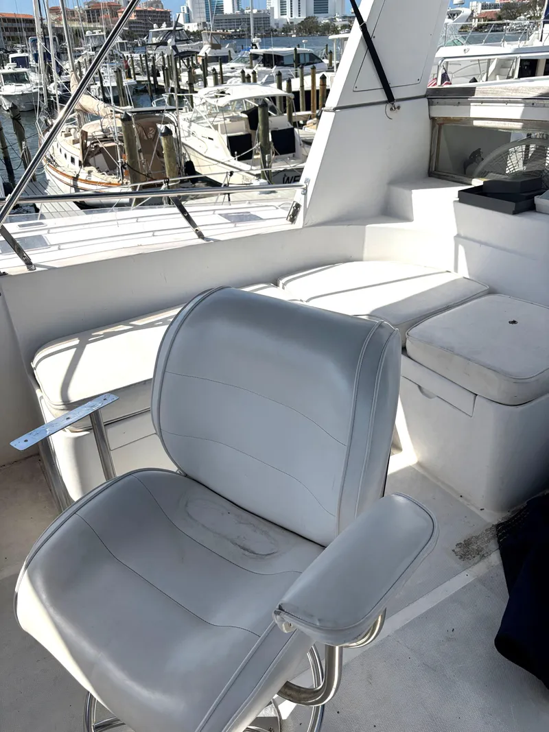 Slide: The Image of 1988 Marine Trader Tradewinds 43 Motor Yacht interior with white seating and marina view. - 21