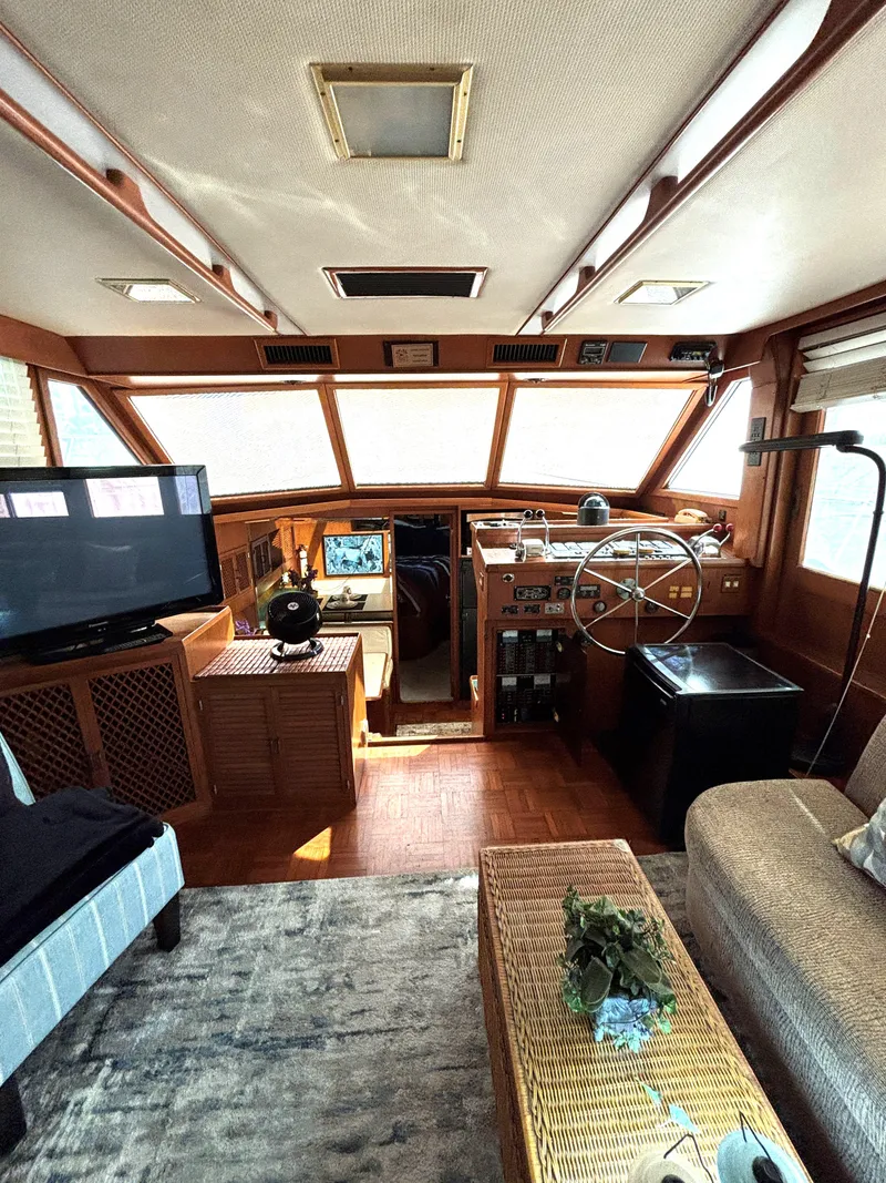 Slide: The Image of Interior of 1988 Marine Trader Tradewinds 43 Motor Yacht, featuring helm and cozy seating area. - 25