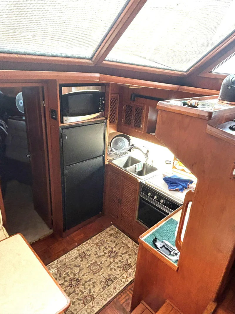 Slide: The Image of 1988 Marine Trader Tradewinds 43 Motor Yacht kitchen with wood cabinetry and modern appliances. - 26