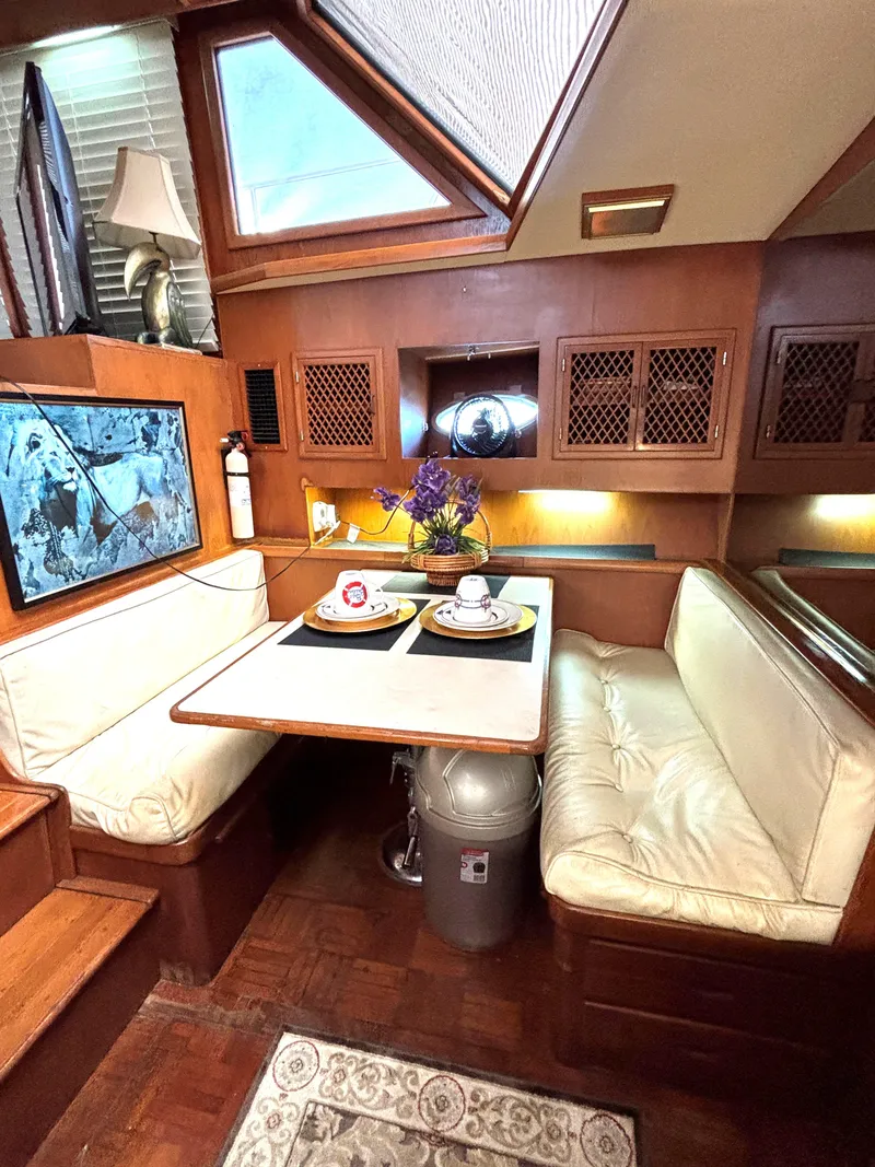 Slide: The Image of Cozy dining area in 1988 Marine Trader Tradewinds 43 Motor Yacht with elegant wood finish. - 31