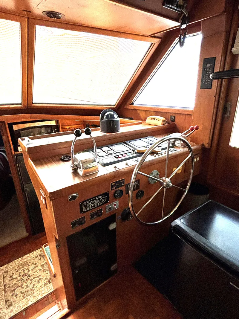 Slide: The Image of 1988 Marine Trader Tradewinds 43 Motor Yacht helm with classic wooden dashboard and steering wheel. - 35