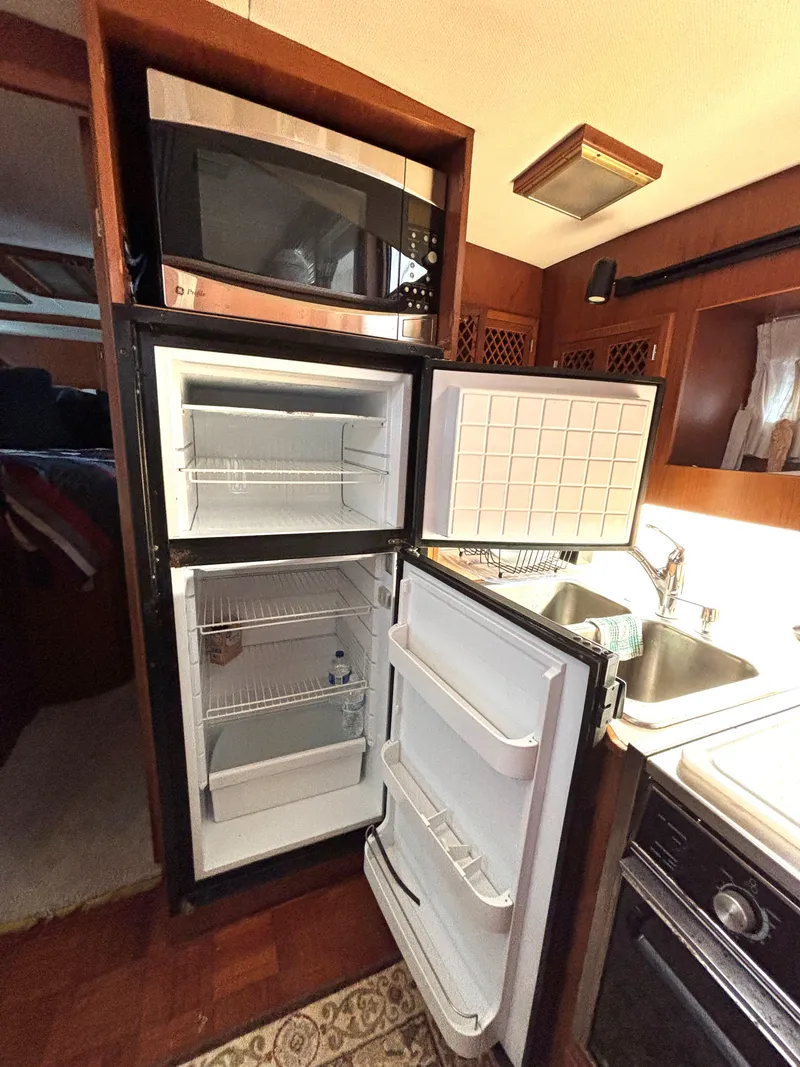 Slide: The Image of 1988 Marine Trader Tradewinds 43 Motor Yacht kitchen with fridge, microwave, and sink. - 43