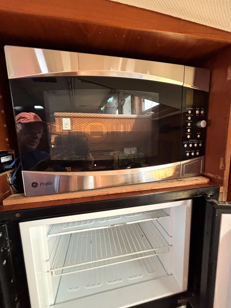 Slide: The Image of Microwave and mini fridge inside 1988 Marine Trader Tradewinds 43 Motor Yacht. - 44