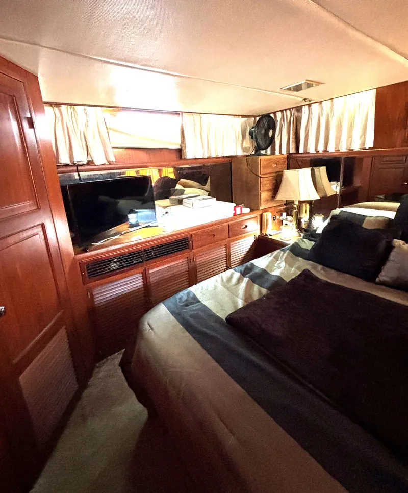 Slide: The Image of Cozy bedroom in 1988 Marine Trader Tradewinds 43 Motor Yacht with wood paneling and TV. - 46