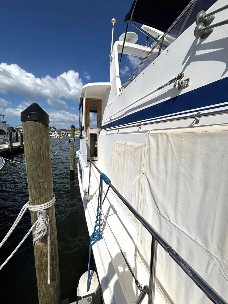 Slide: The Image of 1988 Marine Trader Tradewinds 43 Motor Yacht docked at marina under clear blue sky. - 6