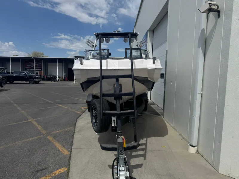 Slide: The Image of 2023 Supra SE 550 boat on trailer outside a building under a clear sky. - 3