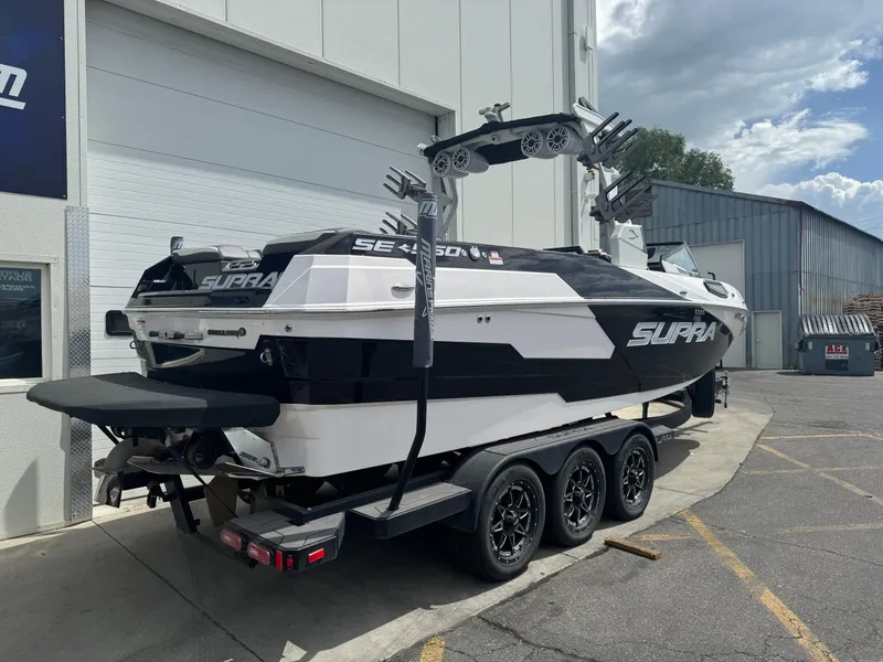 Slide: The Image of 2023 Supra SE 550 boat on trailer, parked outside a building. - 5