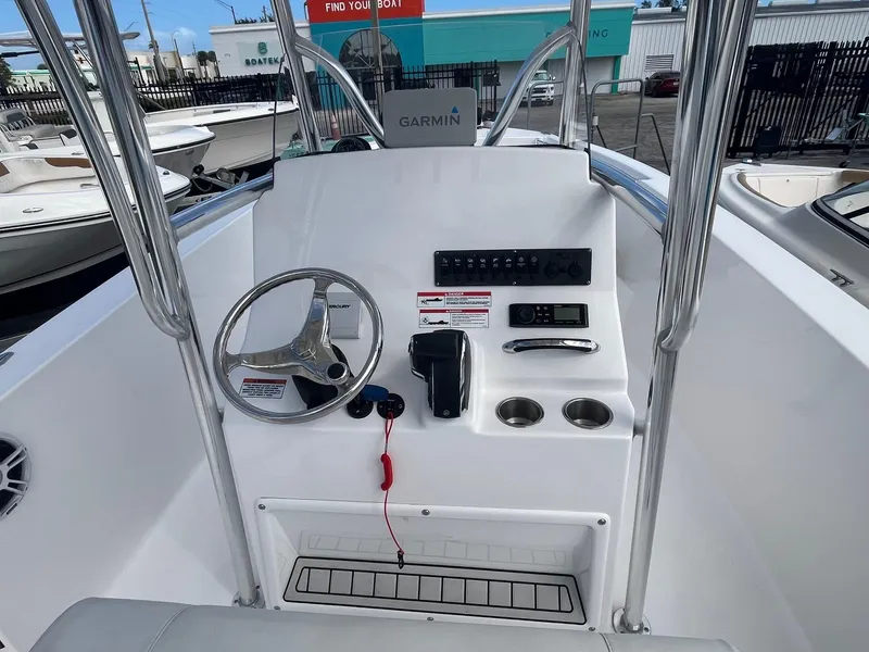 Slide: The Image of 2023 Aquasport 22 CC boat console with steering wheel and controls. - 2