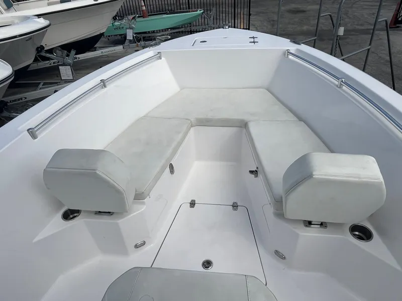 Slide: The Image of 2023 Aquasport 22 CC boat interior with white cushioned seating. - 3