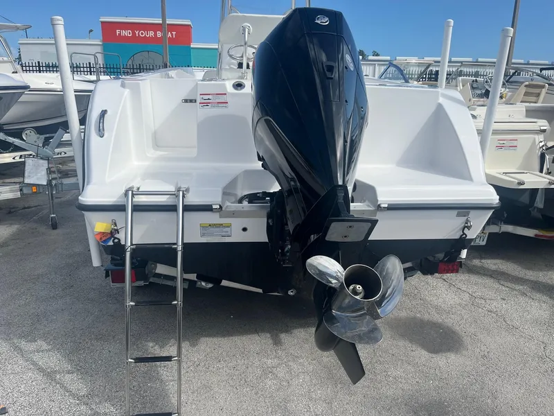 Slide: The Image of 2023 Aquasport 22 CC boat with outboard motor and ladder, displayed in a marina. - 9