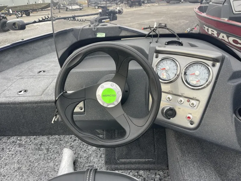 Slide: The Image of 2025 Tracker Pro Guide V-16 SC boat dashboard with steering wheel and gauges. - 10