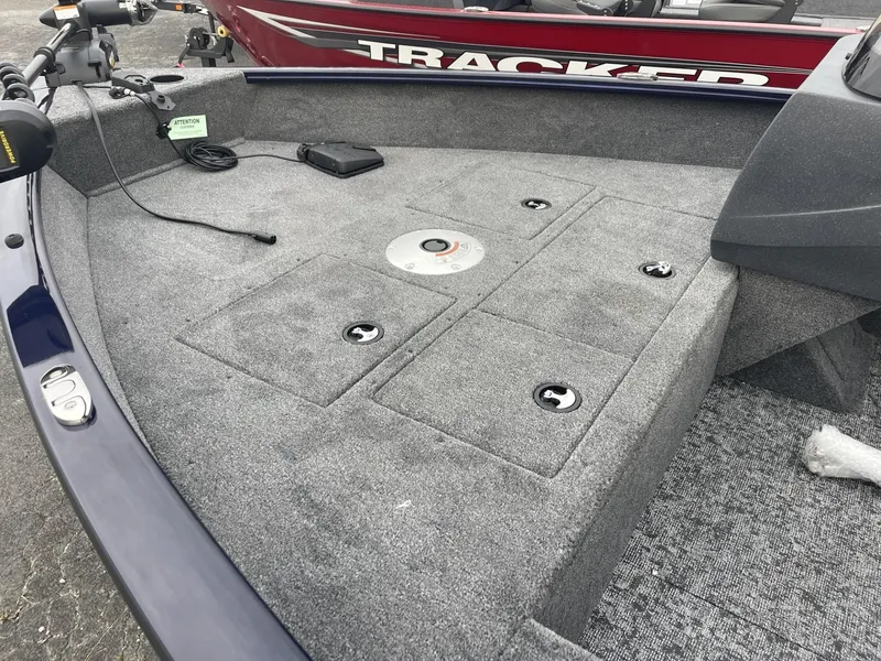 Slide: The Image of 2025 Tracker Pro Guide V-16 SC boat deck with storage compartments and fishing equipment. - 7